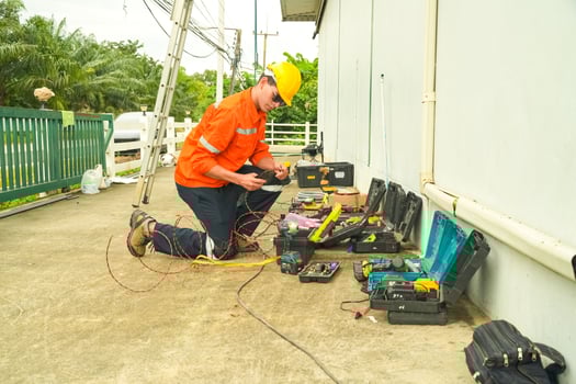 A man in an orange shirt working on a piece of equipment photo