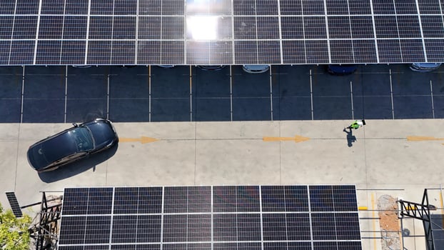 A car drives by a parking lot with solar panels photo