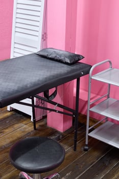 A stylish treatment room with pink walls and modern furniture, creating a tranquil atmosphere photo