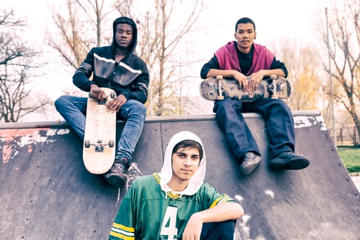 group of young adults sitting on a ramp with skateboard photo