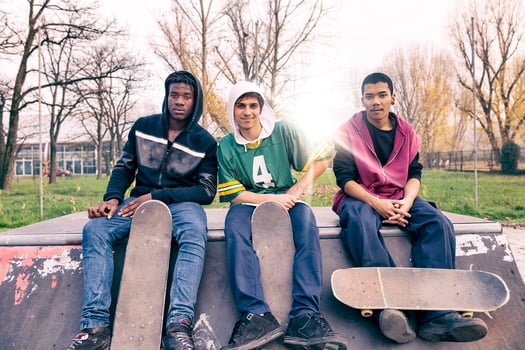 group of young adults sitting on a ramp with skateboard photo