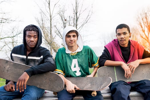 group of young adults sitting on a ramp with skateboard photo