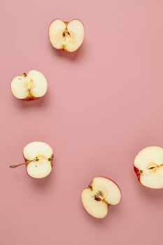 Red apple, half apple and quarter apple on pink background. Top view, healthy food concept. Top view. photo