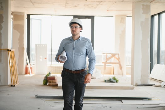 Architect holding blueprints and wearing a helmet photo