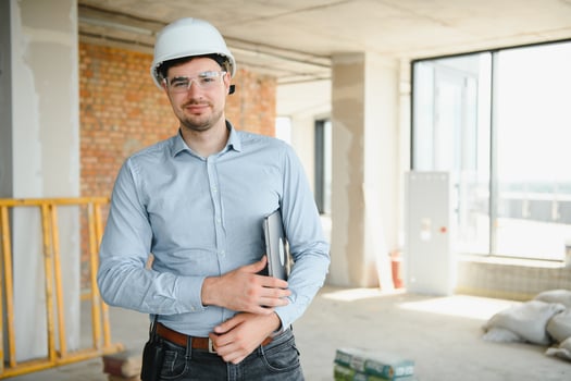 Male architect working on laptop at construction site photo