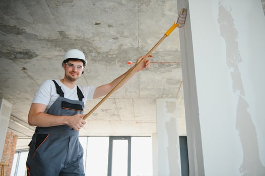 Handsome young male builder in hard hat, while working at construction site. photo