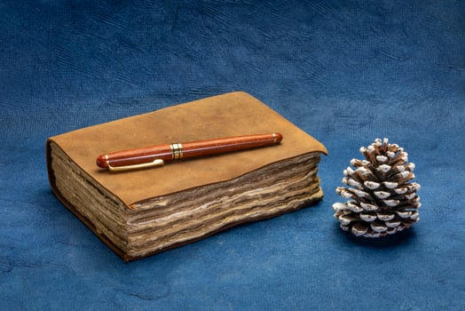 antique leather-bound journal on blue handmade paper photo