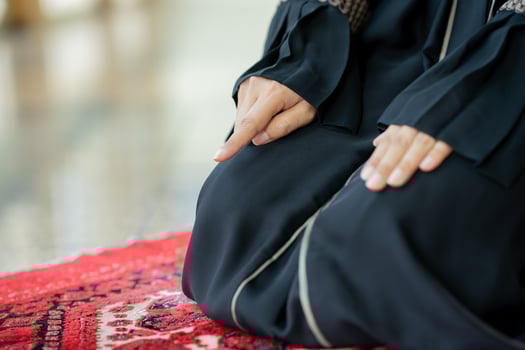 The image of an Asian Muslim woman in the Islamic religion in hijab in cream color. She was praying in a beautiful mosque out of respect for God. photo