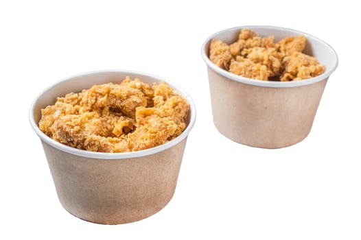 Crunchy chicken popcorn bites in a basket from fastfood. Isolated, white background. photo
