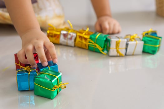 Close up of hand of daughter playing gift box christmas on the floor. photo