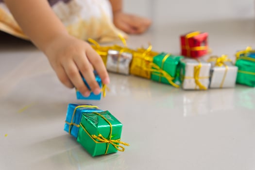 Close up of hand of daughter playing gift box christmas on the floor. photo