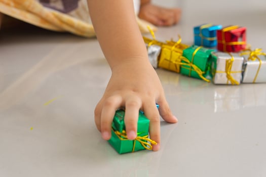 Close up of hand of daughter playing gift box christmas on the floor. photo