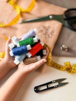 Colorful threads and sewing tools on tailors workspace photo
