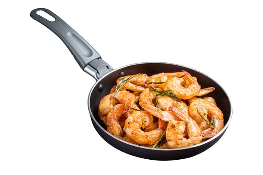 Fried with butter and garlic prawns shrimps in a skillet. Isolated on white background. Top view. photo