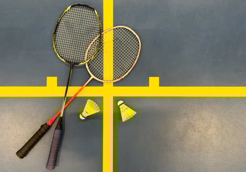 Shuttlecock on badminton racquet on floor. photo