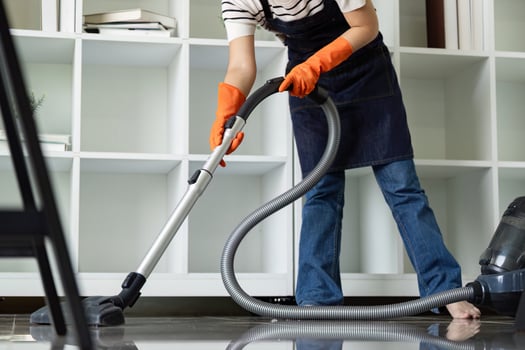 Person Vacuuming Floor in Brightly Lit Modern Interior photo