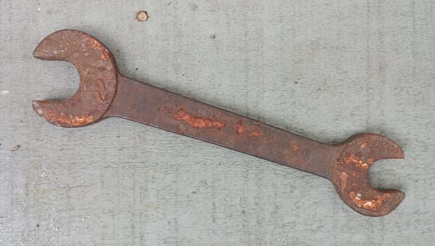 Rusty Wrench on Weathered Painted Green Wooden Surface photo