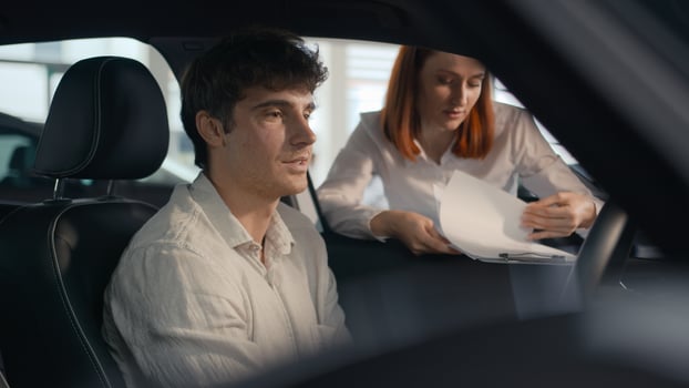 Caucasian seller woman female automobile salon manager trader saleswoman consult client male buyer man helping businessman choose auto explain trade new car to customer male sit inside vehicle rent photo