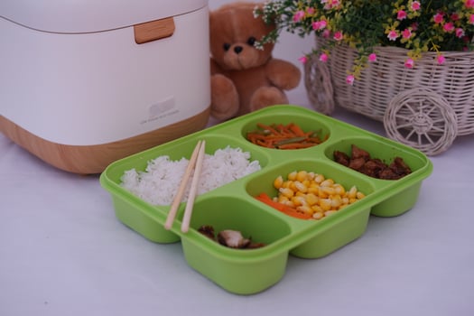 A green tray with five compartments containing delicious food photo