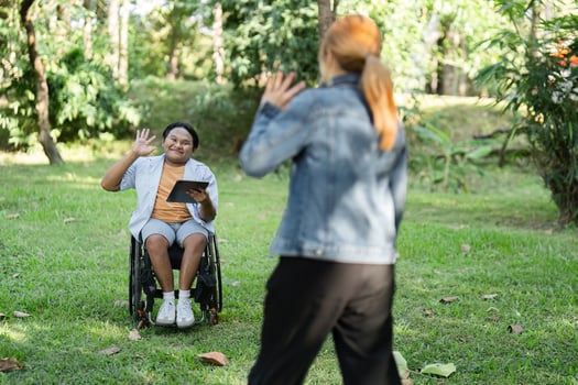 Disabled Young Man in Wheelchair Cheerfully Greets Friend in Park Setting, Embracing Friendship and Inclusivity photo