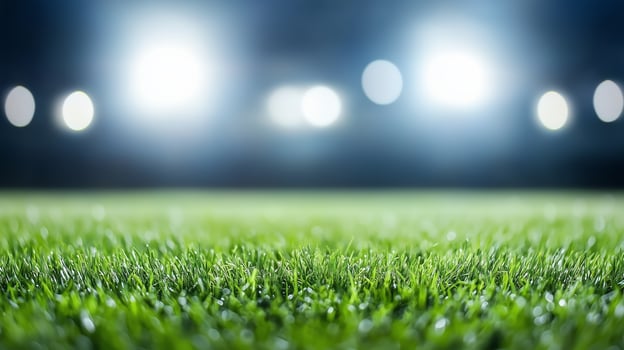 Field illuminated by bright floodlights during a night sporting event with freshly cut grass photo