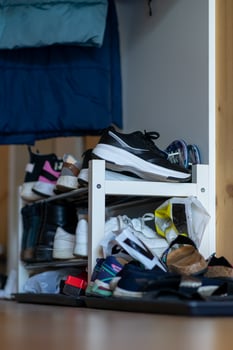 White shoe shelf filled with various shoes in a residential apartment photo