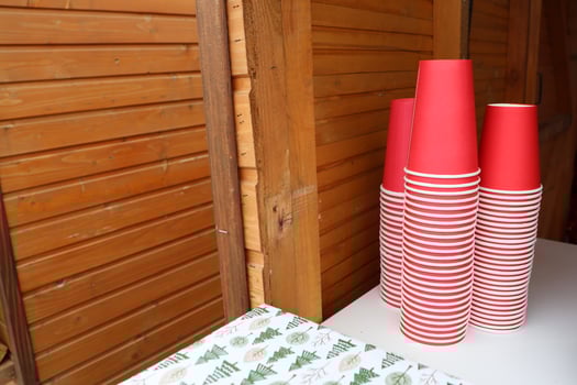 In a charming and inviting rustic setting, a vibrant stack of perky red cups sits on a table photo