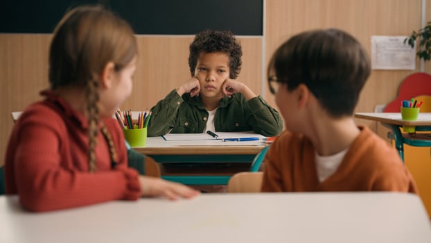 Multiracial diverse noisy little classmates multiethnic students pupils people children diversity kids friends noisy talking in school class at lesson sitting at table education learning studying talk photo