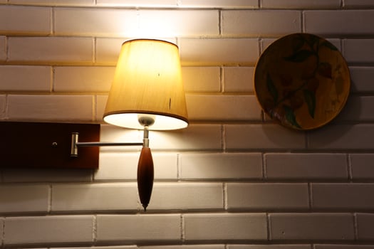 Elegant Wall Lamp paired with a Decorative Plate adorning a rustic Brick Wall background photo
