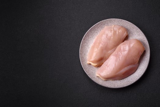 Pieces of raw chicken or turkey fillet with salt, spices and herbs photo