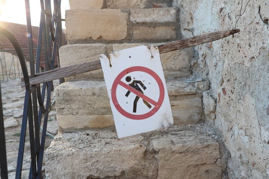 There is a No Walking Sign installed on the rustic, uneven stone steps for safety purposes photo