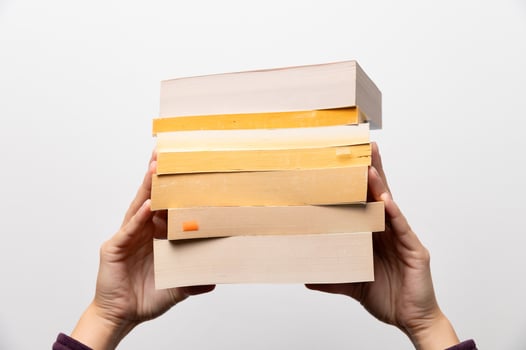 Stack of books in hand, Book Day, several books in hands on neutral white background. Home leisure. Self-isolation home, home schooling photo