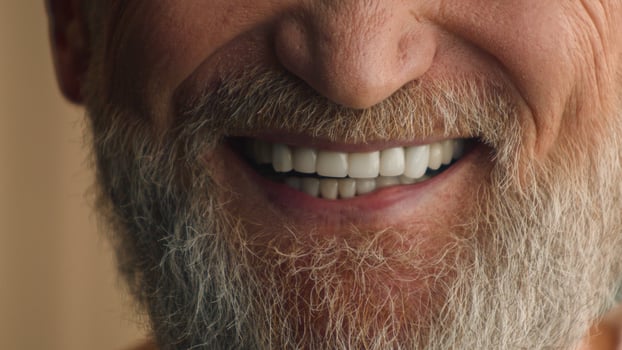Close up male white healthy teeth smiling cropped view happy satisfied smile cheerful positive unrecognizable old senior mature man with gray hair beard bearded grandfather dental prostheses medicine photo