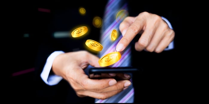 Making money online concept. Male hand touching screen phone with dollar bills coming out close-up photo