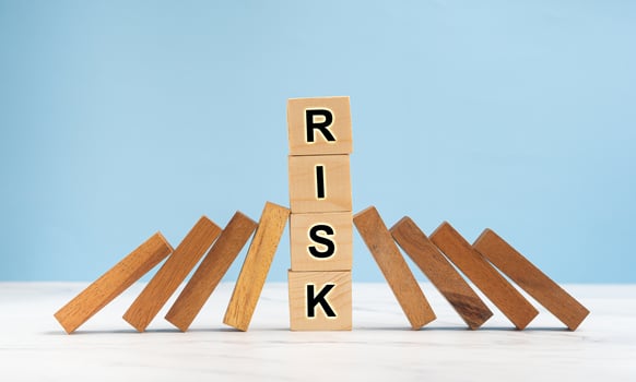 Risk management and strategy in business. Close-up of wooden blocks on a line of dominos over a marble floor with a blue background photo