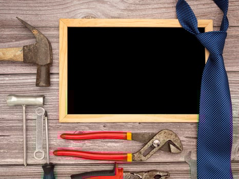 Happy Father's Day. A blank mini chalkboard, necktie, and construction tools on a wooden table photo
