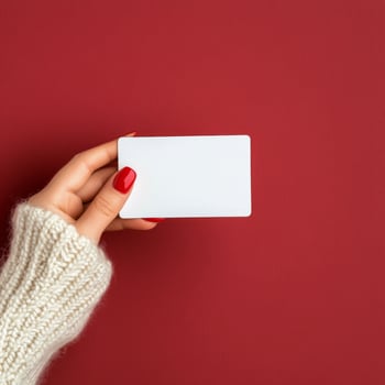 Person holding a blank card with red background and cozy sweater photo