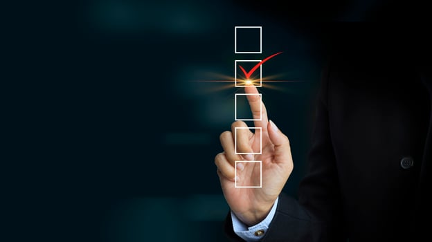 Checking mark on checklist with a red marker on dark background photo