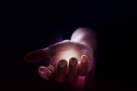 a person holding a glowing light in their hand photo