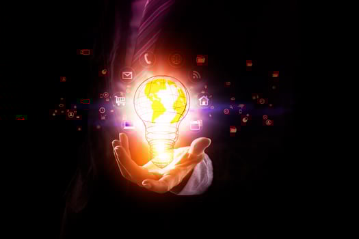 a person in a suit holding a glowing light bulb photo