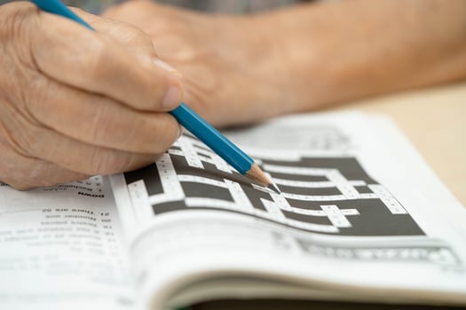 elderly woman playing sudoku puzzle game. photo