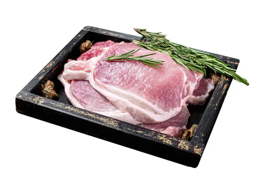 Ready for cooking raw pork chop steaks in a wooden tray with rosemary. Isolated on white background. Top view. photo