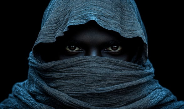 A man with a hood over his head and a black face. The hood is blue and the man's face is black photo