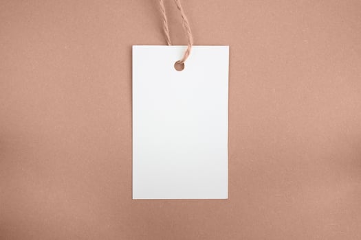 White price tag on a brown background. Mockup. Place for text. photo