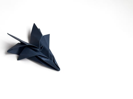 Elegant dark blue origami stork on minimalist white background photo