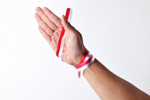 Hands spread with a red and white ribbon photo