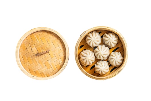 Steamed baozi dumplings stuffed with meat in a bamboo steamer. Isolated on white background. photo