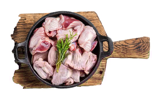 Raw chicken giblets gizzards, stomachs in a skillet ready for cooking. Isolated, white background. photo