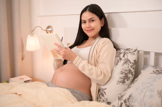 Beautiful pregnant woman writing a diary to baby, fertility infertility treatment, IVF, future maternity concept photo