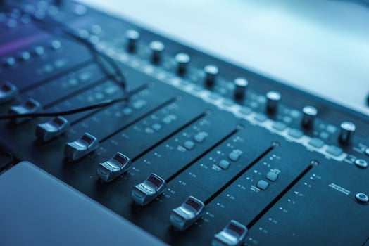 Close Up of Professional Audio Mixing Console with Sliders and Knobs photo